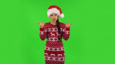 Noel Baba şapkalı tatlı kız jest yapıyor. Buraya gel. Yeşil Ekran