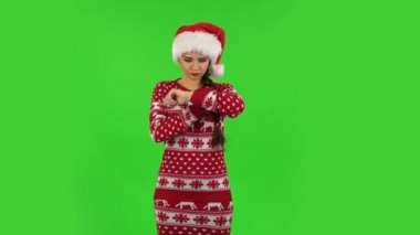 Noel Baba şapkalı tatlı kız bekliyor ve kızgın. Yeşil Ekran