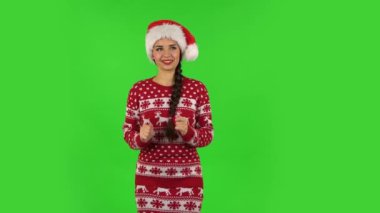 Noel Baba şapkalı tatlı kız zevkle bekliyor. Yeşil Ekran