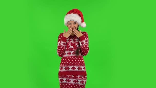 Милая девочка в шляпе Санта Клауса смеется, глядя в камеру. Зеленый экран — стоковое видео