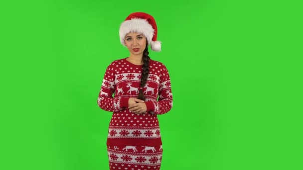 Sweety girl in cappello di Babbo Natale sta riportando e raccontando un sacco di informazioni interessanti. Schermo verde — Video Stock