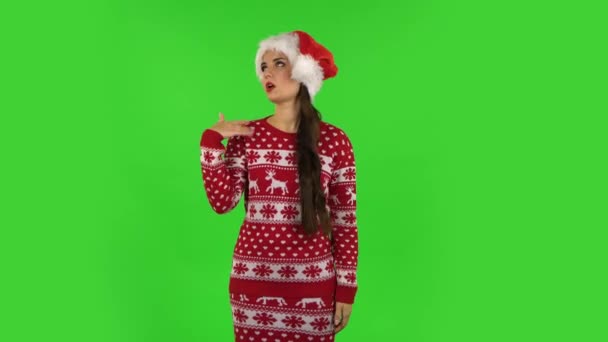 Sweety girl in Santa Claus hat is cooling herself by her hand, suffering from high temperature weather. Pantalla verde — Vídeo de stock