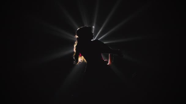 Untere Ansicht einer Silhouette einer Frau, die Flamenco-Tanzelemente im Scheinwerferlicht vorführt. Zeitlupe. — Stockvideo