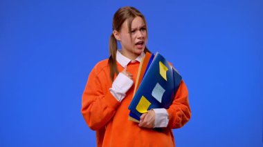 Turuncu süveter giyen genç bir kız öğrenci elinde notlar ve kağıtlarla mavi bir arkaplanda dururken el hareketi yapıyor. Eğitim ve öğrenim hayatı.