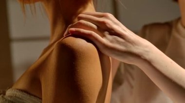 Masaj terapisti bir kadına omuz masajı yapar. Sakinleştirici teknikler ve temel yağlar kullanarak stresi azaltmayı ve rahatlamayı amaçlayan rahatlatıcı bir masaj. Yavaş çekim