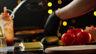 Şef bir barda ya da fast food restoranında kendine bir burger yapmak için taze çörek pişiriyor. Taze, sağlıklı malzemelerden yiyecek hazırlama süreci.