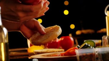 Şef taze bir çöreğin üzerine ketçap ve hardal dökerek bir barda ya da fast food restoranında kendine özgü bir burger yapıyor. Taze, sağlıklı malzemelerden yiyecek hazırlama süreci.