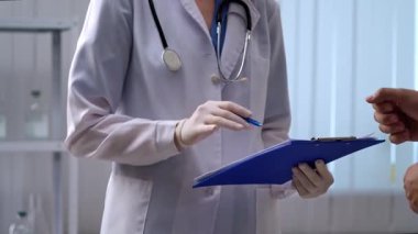 Bir doktor ve hasta, farklı ilaç seçeneklerini tıbbi muayenehanede tartışıyorlar..