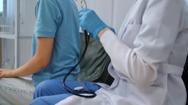 Bir sağlık uzmanı, bir hastayı muayene etmek için steteskop kullanır. Klinik bir ortamda düzgün bir tıbbi bakım sağlar. Tıp ve sağlık hizmetleri kavramı.