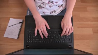 Evden çalışan biri, dizüstü bilgisayarını ahşap zeminde kullanıyor.