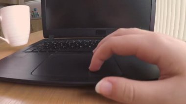 Evdeki yemek masasında çalışırken bilgisayarında daktilo yazan birini kapat.