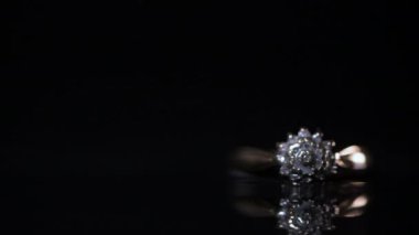 Altın bir nişan yüzüğünde elmaslar parlıyor.