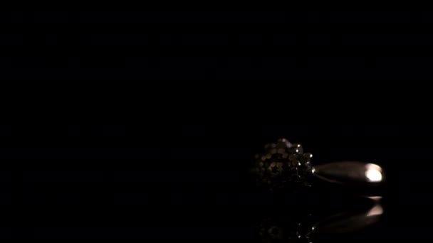 暗い反射性の背景に金のダイヤモンドの婚約指輪の上を移動する光 — ストック動画