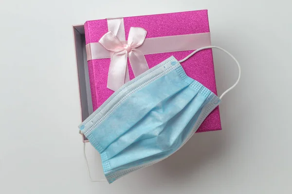 Una pequeña caja de regalo rectangular sobre un fondo blanco abierto con mascarilla — Foto de Stock