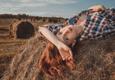 Genç ve güzel bir kız samanlıkta yatıyor.