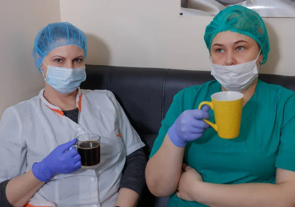 Steril maskeli ve üniformalı bir kadın doktor covid-19 koronavirüs salgını sırasında ara vermiş.