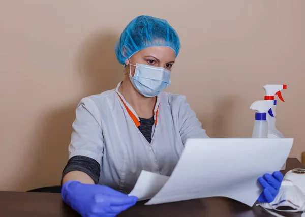 Steril maskeli ve üniformalı bir kadın doktor covid-19 koronavirüs salgınını önledikten sonra ara verdi.