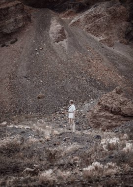 Savaştan sonra elinde bir hançerle dağlarda dinlenen savaşçı gezgin.