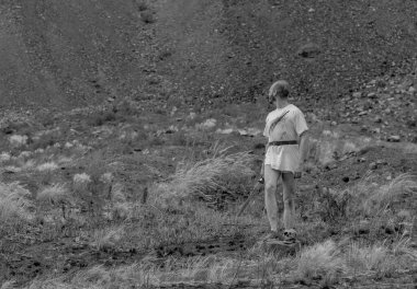 Savaştan sonra elinde bir hançerle dağlarda dinlenen savaşçı gezgin.