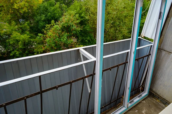 Summer work on installation of plastic frames and double glazing of the balcony close up