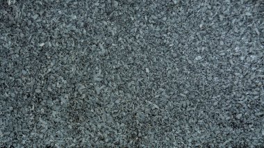 Farklı boyutlarda gri beyaz ve siyah renkli küçük taşlardan oluşan gözenekli bir doku. Bulanık odak