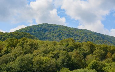 Yazın bulutlu mavi gökyüzüne karşı güzel bir dağ sırası. bulanık odak
