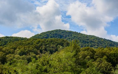 Yazın bulutlu mavi gökyüzüne karşı güzel bir dağ sırası. bulanık odak