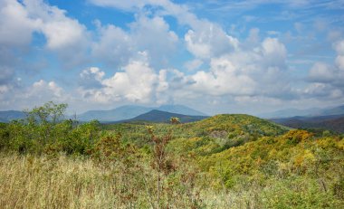 Yazın bulutlu mavi gökyüzüne karşı güzel bir dağ sırası. bulanık odak