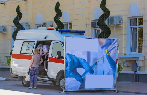 Yoğun bakım ünitesinden bir doktor, gezici bir laboratuvarda, covid-19 koronavirüs salgını için karantina sırasında sokaktaki insanlara önleyici aşılar yapıyor. Bulanık odak