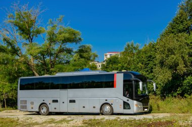 Yakın planda bulunan gümüş renkli bir turist otobüsü yolcuları bekliyor. bulanık odak