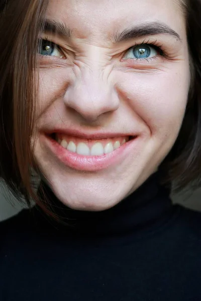 Girl in black clothes with green eyes ominously smiles — Stock Photo, Image