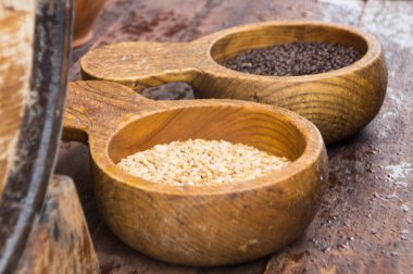 Light and dark barley malt in wooden ladles