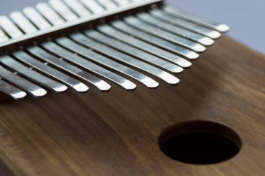 Ahşap bir müzik aletinin metal anahtarları, kalimba yakın plan.