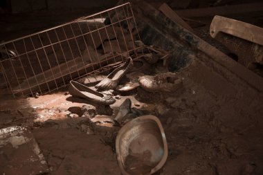 Mariana, Minas Gerais, Brezilya - 29 Şubat 2016: Vale do Rio Doce madencilik şirketinde Bento Rodrigues baraj faciasının gömdüğü bir aile evinin zemininde Utensiller ve ayakkabılar
