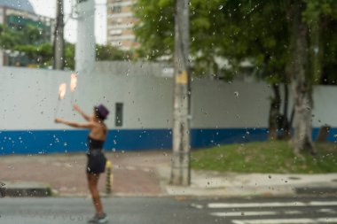 Rio de Janeiro, Brezilya - 03 Mart 2016: Yağmurlu bir günde kadın şehir trafiğinde hokkabazlık yapıyor