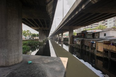 Bangkok, Tayland - 18 Nisan 2011: Bangkok 'un kenar mahallelerindeki Khlong Toei kanalizasyon sisteminin altında gecekondu mahallesi
