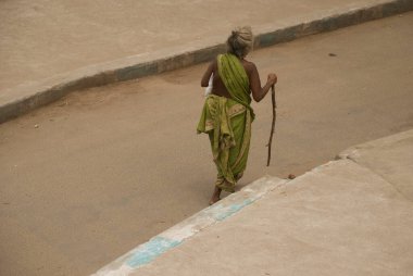 Madurai, Tamil Nadu, Hindistan - 22 Ekim 2010: Madurai sokaklarında yürüyen evsiz kadın. Hindistan 'da bugün 1.8 milyon evsiz olduğu tahmin edilmekte olup, bunların% 52' si kentsel bölgelerde bulunmaktadır (2019)