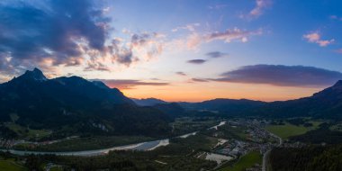 Avustralya dağlarındaki Pflach köyünün panoraması ve renkli günbatımında nehir şehveti. 