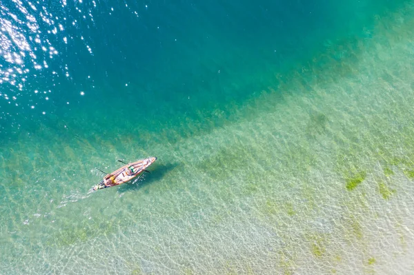 緑の澄んだ湖の上に船で2人のパドルを空中から見る — ストック写真