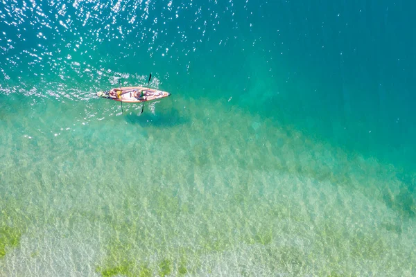 晴れた日にはカヤックできれいな湖を渡る2人の観光客が — ストック写真