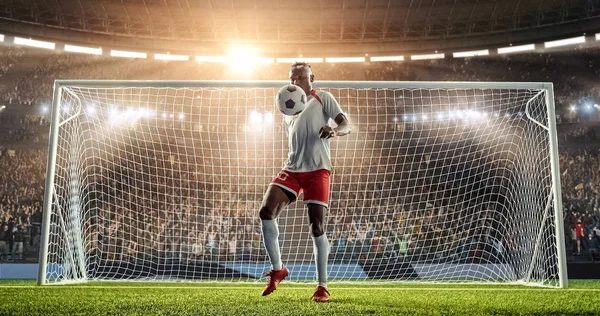 Soccer player is juggling a ball with his legs in front of the goal on a professional soccer stadium. Stadium and crowd are made in 3D.