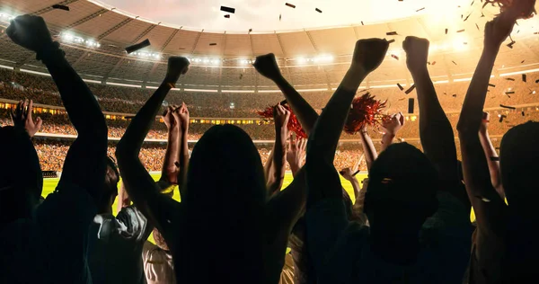 Group of cheering fans watch a sport championship on stadium. Their team wins and everybody are celebrating this event. People are dressed in casual cloth.