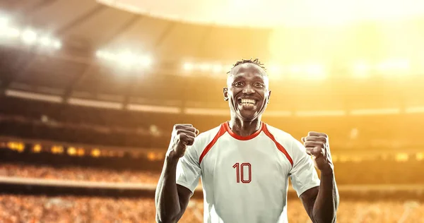 Happy soccer player celebrate a victory on a professional football stadium