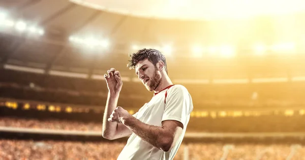 Happy soccer player celebrate a victory on a professional football stadium