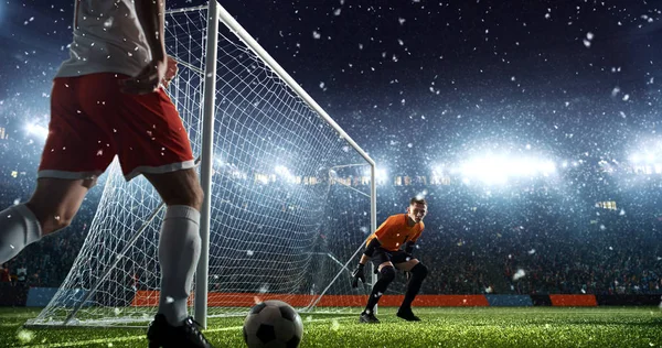 雪が降っている中 プロのサッカー スタジアムのゴール前での強烈なサッカー瞬間 競技場と観客は で作られています — ストック写真