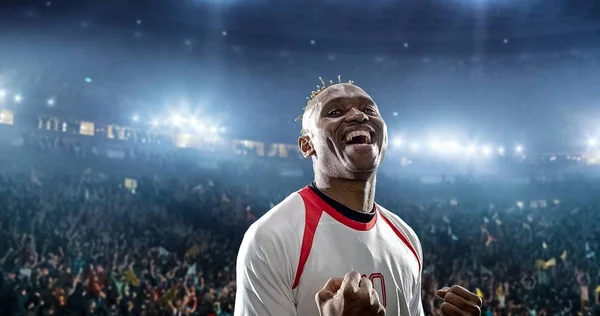 Happy soccer player celebrate a victory on a professional football stadium