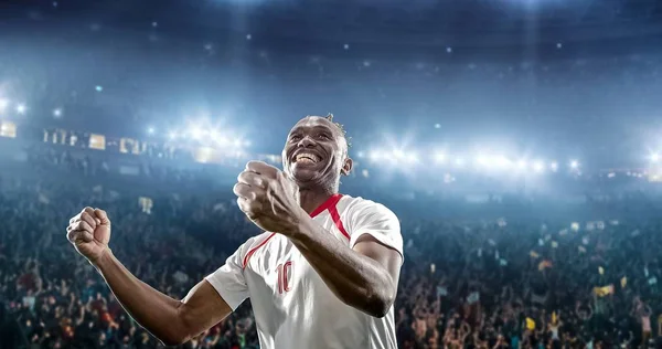 Happy soccer player celebrate a victory on a professional football stadium