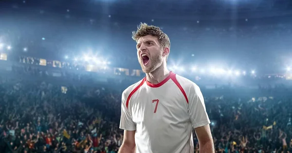 Happy soccer player celebrate a victory on a professional football stadium