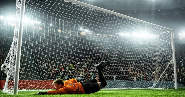 Soccer goalkeeper in action on the soccer stadium. He wear unbranded sports clothes. Stadium and crowd made in 3D.