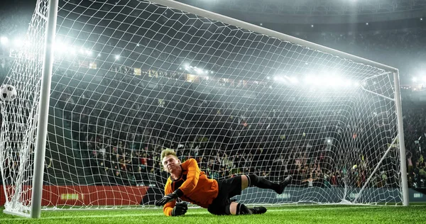 Soccer goalkeeper in action on the soccer stadium. He wear unbranded sports clothes. Stadium and crowd made in 3D.